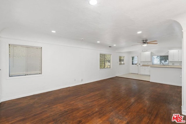 unfurnished living room with ceiling fan, dark hardwood / wood-style flooring, and sink