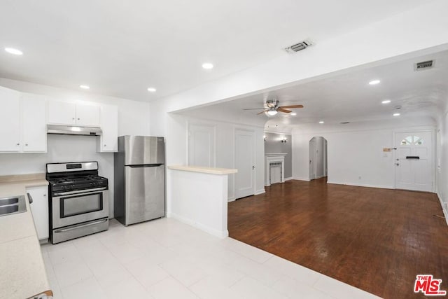 kitchen featuring light wood-type flooring, stainless steel appliances, ceiling fan, sink, and white cabinets