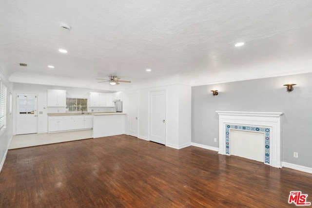 unfurnished living room featuring ceiling fan and dark hardwood / wood-style floors