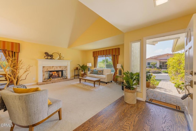 living room with a fireplace, vaulted ceiling, and hardwood / wood-style flooring