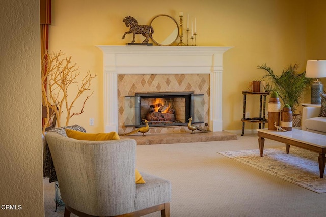 living area featuring carpet flooring and a tile fireplace