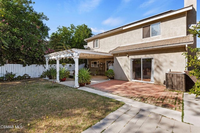 rear view of property featuring a patio area, a pergola, and a yard