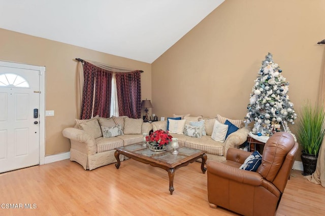 living room with high vaulted ceiling and light wood-type flooring