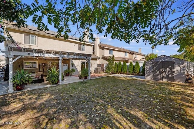 rear view of house with a patio area, a pergola, a lawn, and a storage shed