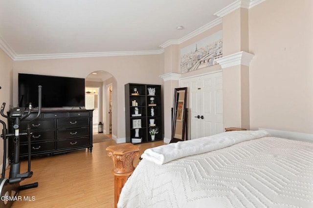 bedroom with lofted ceiling, light hardwood / wood-style floors, and crown molding