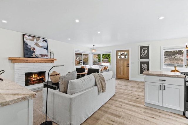 living room with light hardwood / wood-style floors and a brick fireplace