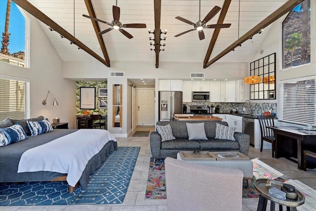 bedroom with beam ceiling, stainless steel fridge, and high vaulted ceiling