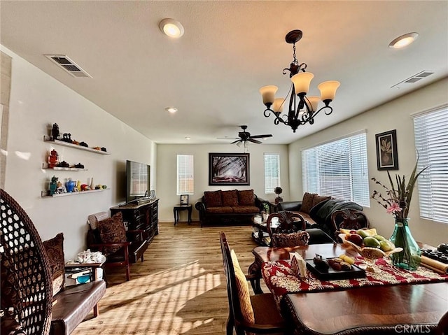 living room with hardwood / wood-style flooring and ceiling fan with notable chandelier