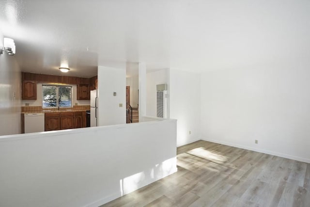 kitchen with white appliances and light hardwood / wood-style flooring