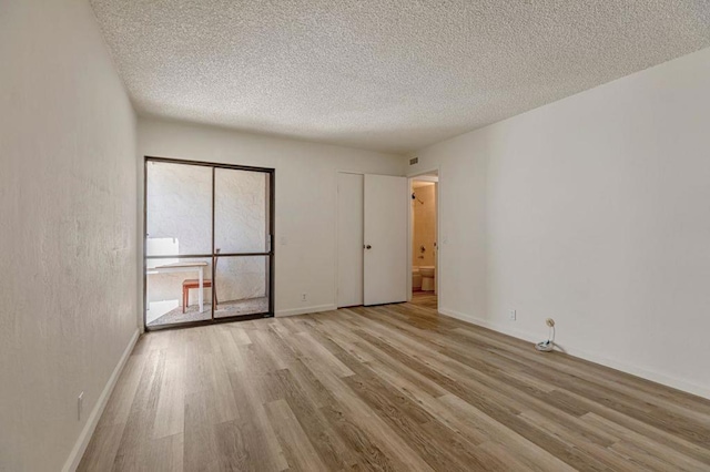 empty room featuring light hardwood / wood-style flooring and a textured ceiling