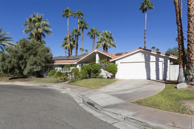 view of front of property featuring solar panels, a garage, and a front yard