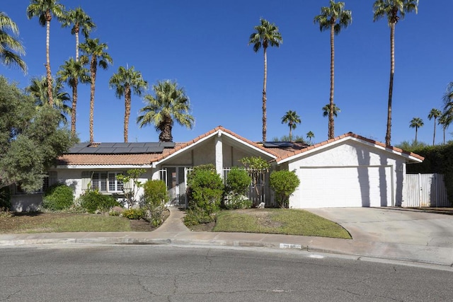 single story home with solar panels and a garage