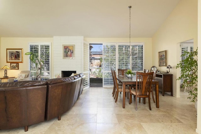 dining area with vaulted ceiling and a fireplace