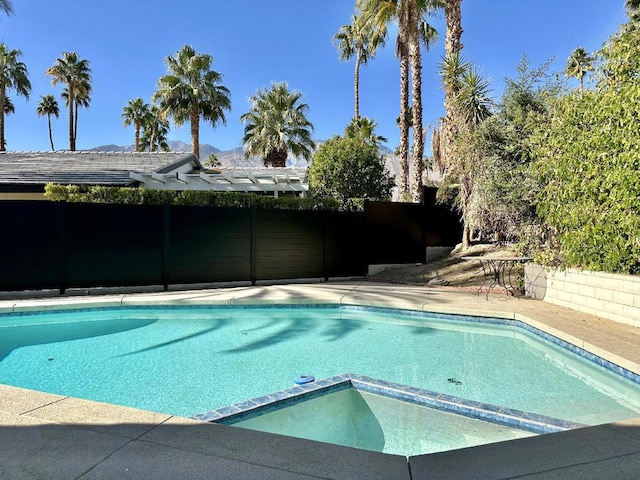 view of swimming pool with an in ground hot tub