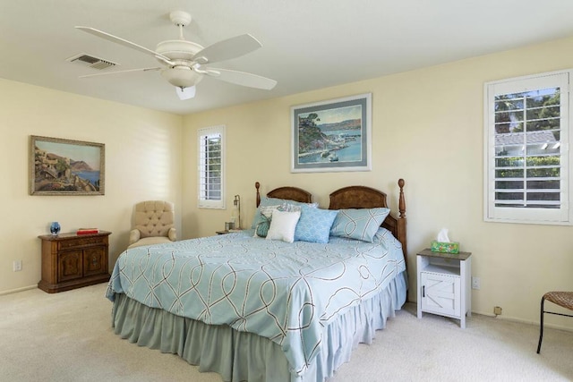 carpeted bedroom with multiple windows and ceiling fan