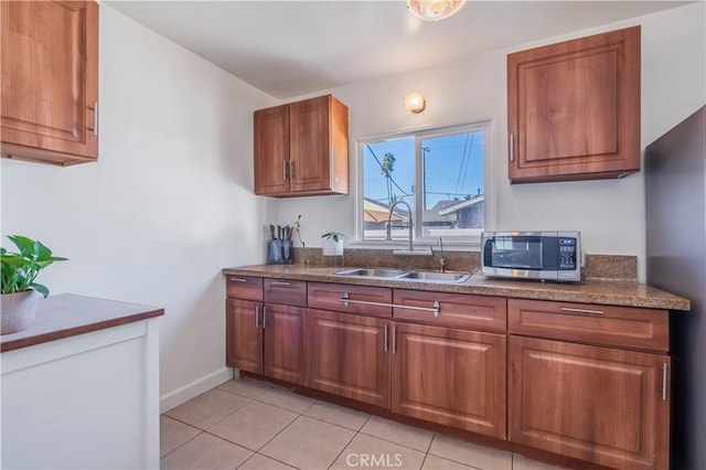 kitchen featuring sink, stainless steel appliances, and light tile patterned flooring