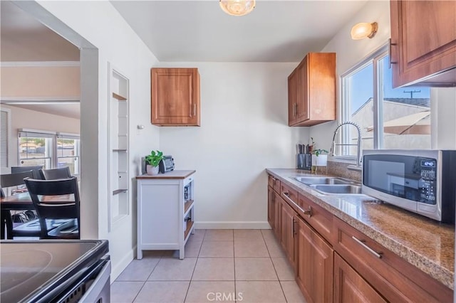 kitchen with light tile patterned floors, appliances with stainless steel finishes, ornamental molding, and sink