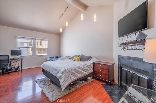 bedroom with dark wood-type flooring and lofted ceiling with beams