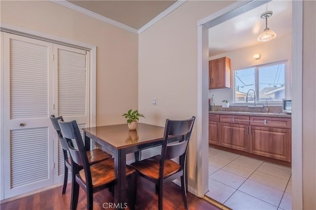 dining area with light tile patterned floors and ornamental molding