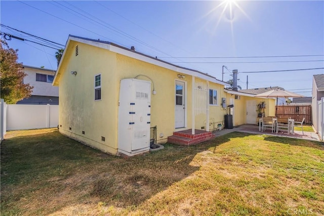 rear view of house featuring a yard and a patio