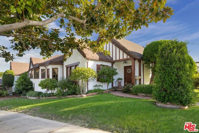 english style home featuring a front yard