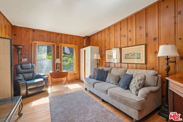 living room with wood walls and light hardwood / wood-style floors