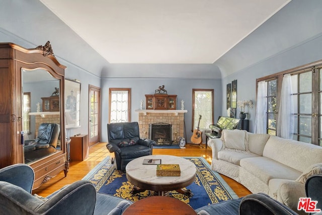 living room with a tile fireplace and light hardwood / wood-style floors