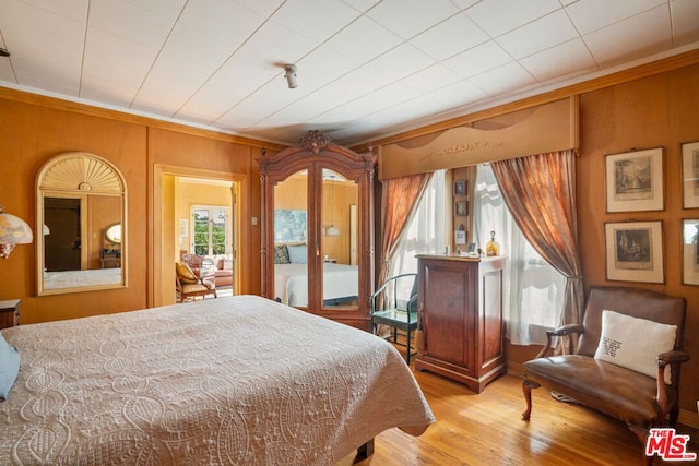 bedroom featuring wood walls and light wood-type flooring