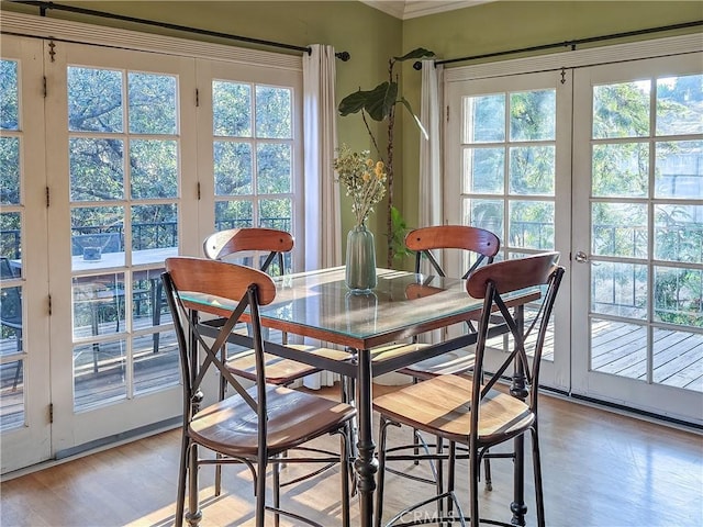 dining area with plenty of natural light, light wood-type flooring, and ornamental molding