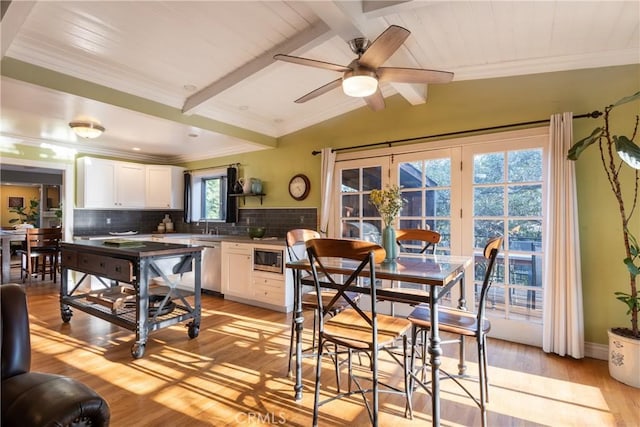 dining space with lofted ceiling with beams, light hardwood / wood-style flooring, plenty of natural light, and ceiling fan