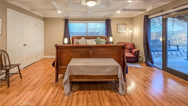 bedroom featuring light wood-type flooring, access to outside, multiple windows, and coffered ceiling