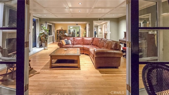 living room with light hardwood / wood-style floors and coffered ceiling