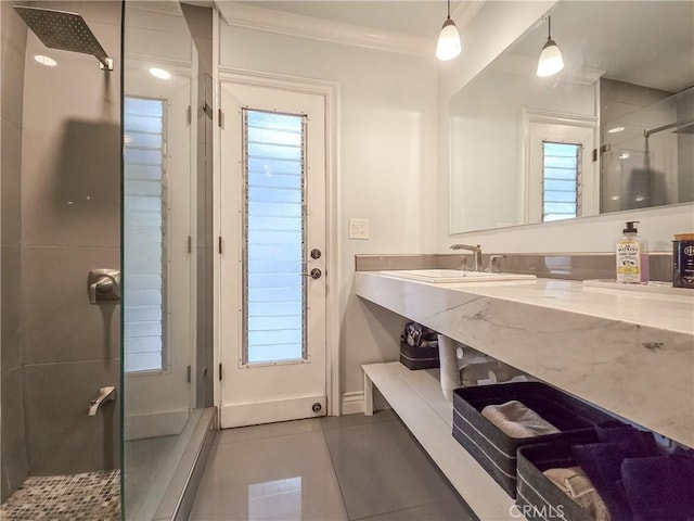 bathroom featuring tile patterned flooring, an enclosed shower, ornamental molding, and sink