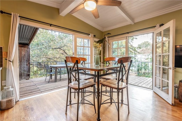 dining area with light wood-type flooring, lofted ceiling with beams, ceiling fan, and crown molding