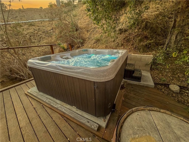 deck at dusk with a hot tub