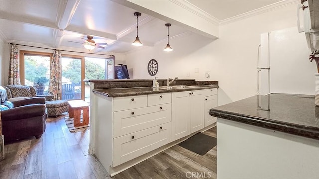 kitchen featuring white cabinets, dark hardwood / wood-style floors, beam ceiling, and sink