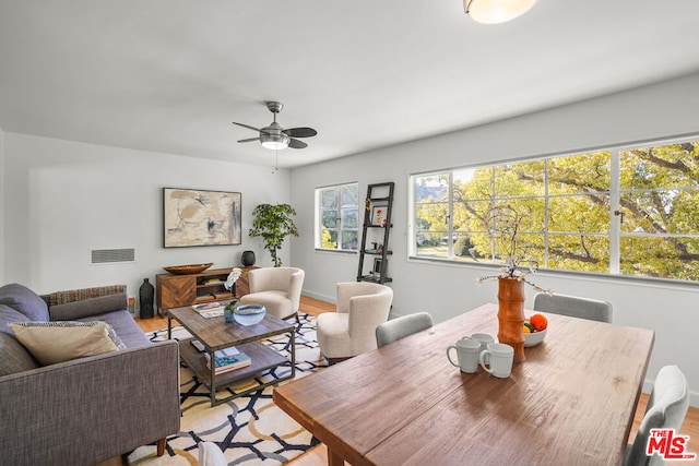 dining space with ceiling fan and light hardwood / wood-style flooring