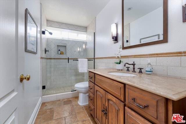 bathroom featuring vanity, toilet, tile walls, and walk in shower