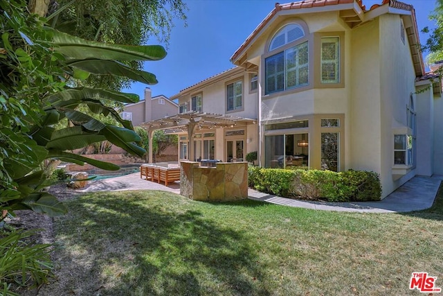 rear view of property featuring a pergola, a patio area, and a lawn