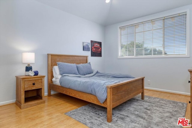 bedroom featuring light wood-type flooring and lofted ceiling