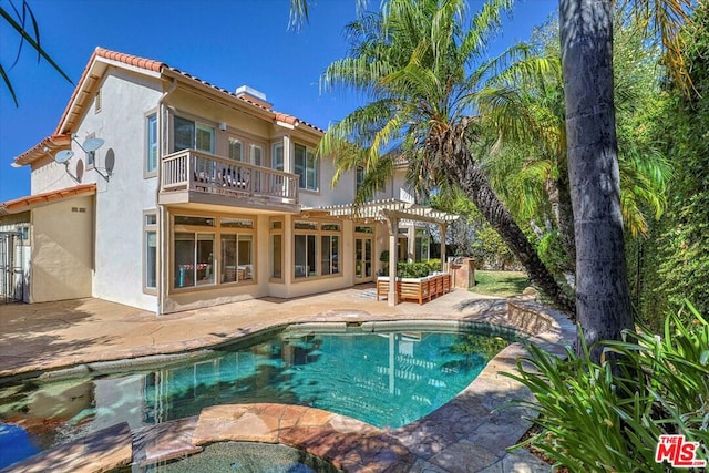 back of house with a balcony, a pergola, and a patio