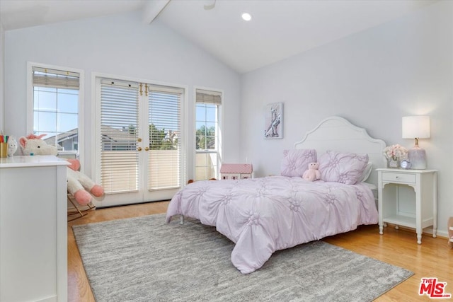 bedroom featuring light wood-type flooring and lofted ceiling with beams