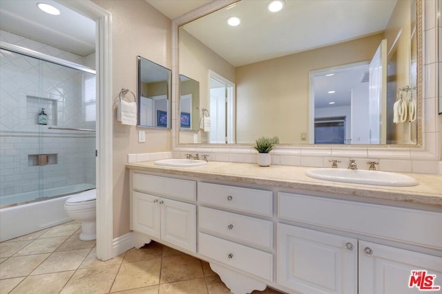 full bathroom featuring toilet, tile patterned flooring, vanity, and combined bath / shower with glass door