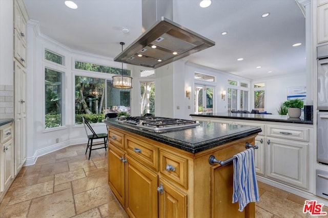 kitchen with an inviting chandelier, stainless steel gas stovetop, island range hood, a kitchen island, and ornamental molding