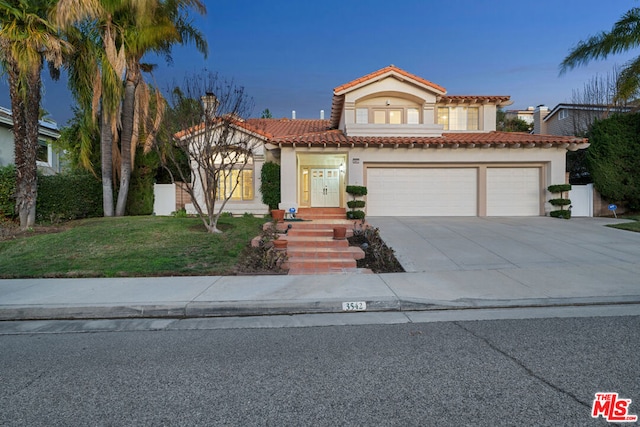 mediterranean / spanish-style house featuring a garage and a yard