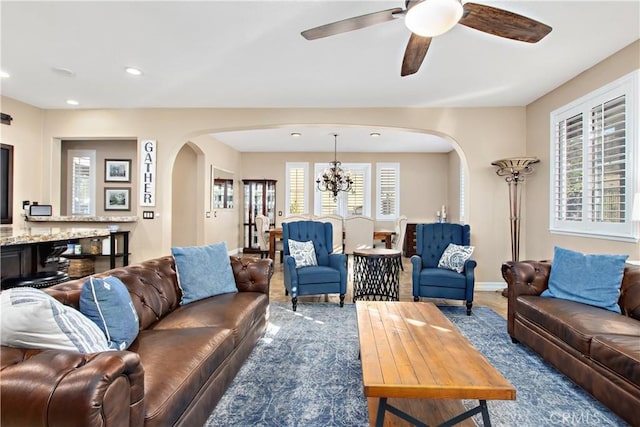 living room featuring hardwood / wood-style floors and ceiling fan with notable chandelier