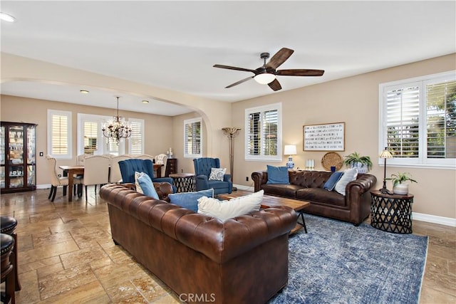 living room with ceiling fan with notable chandelier and a healthy amount of sunlight