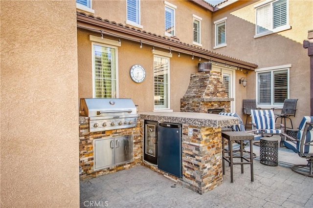 view of patio / terrace with an outdoor kitchen, area for grilling, and a bar