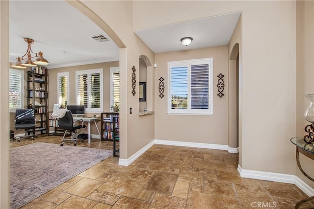 entryway featuring a notable chandelier and ornamental molding