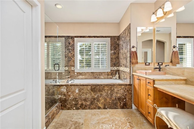 bathroom with plus walk in shower, plenty of natural light, and vanity